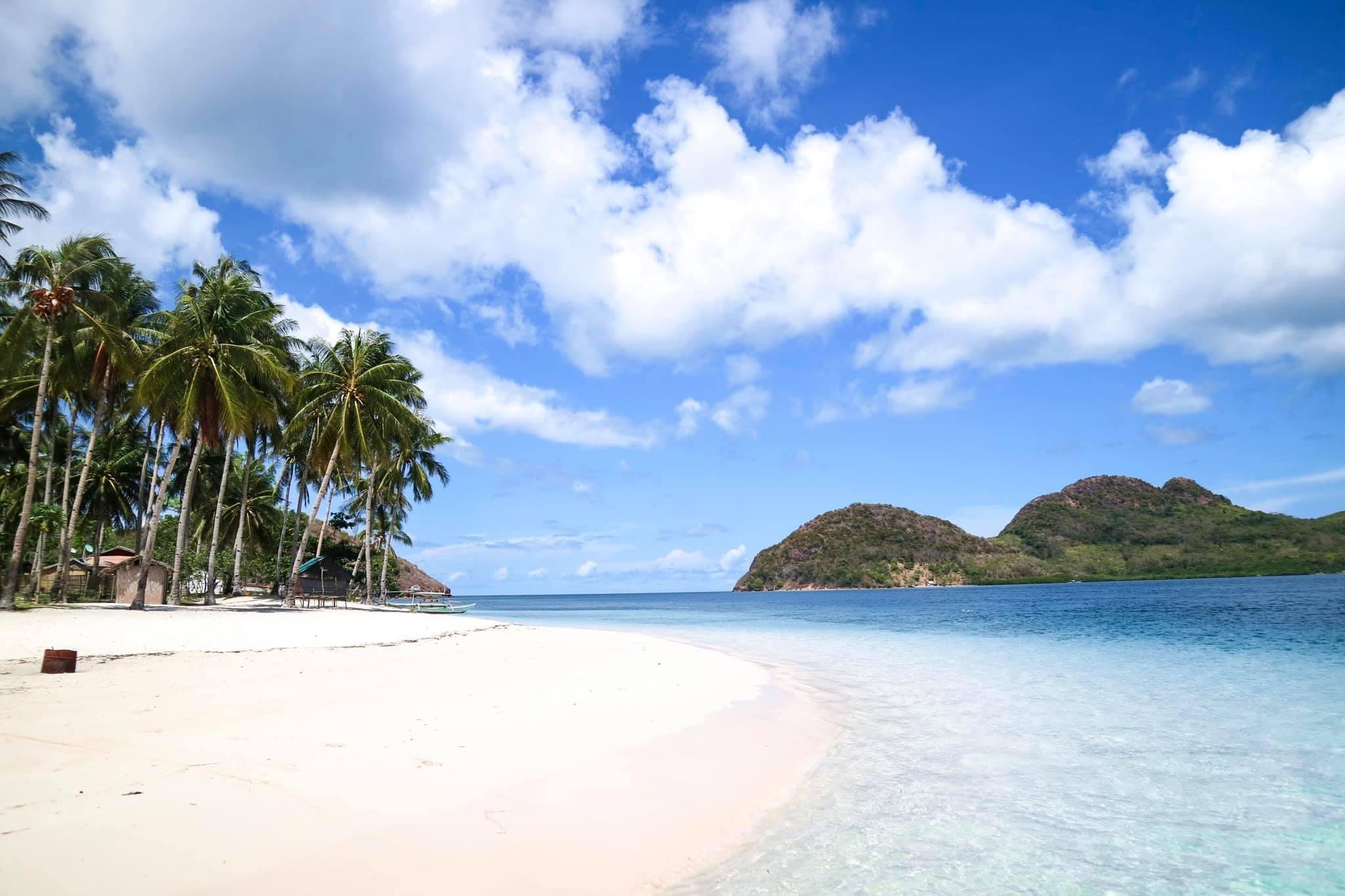 Island hopping in the Philippines on white sand beaches.