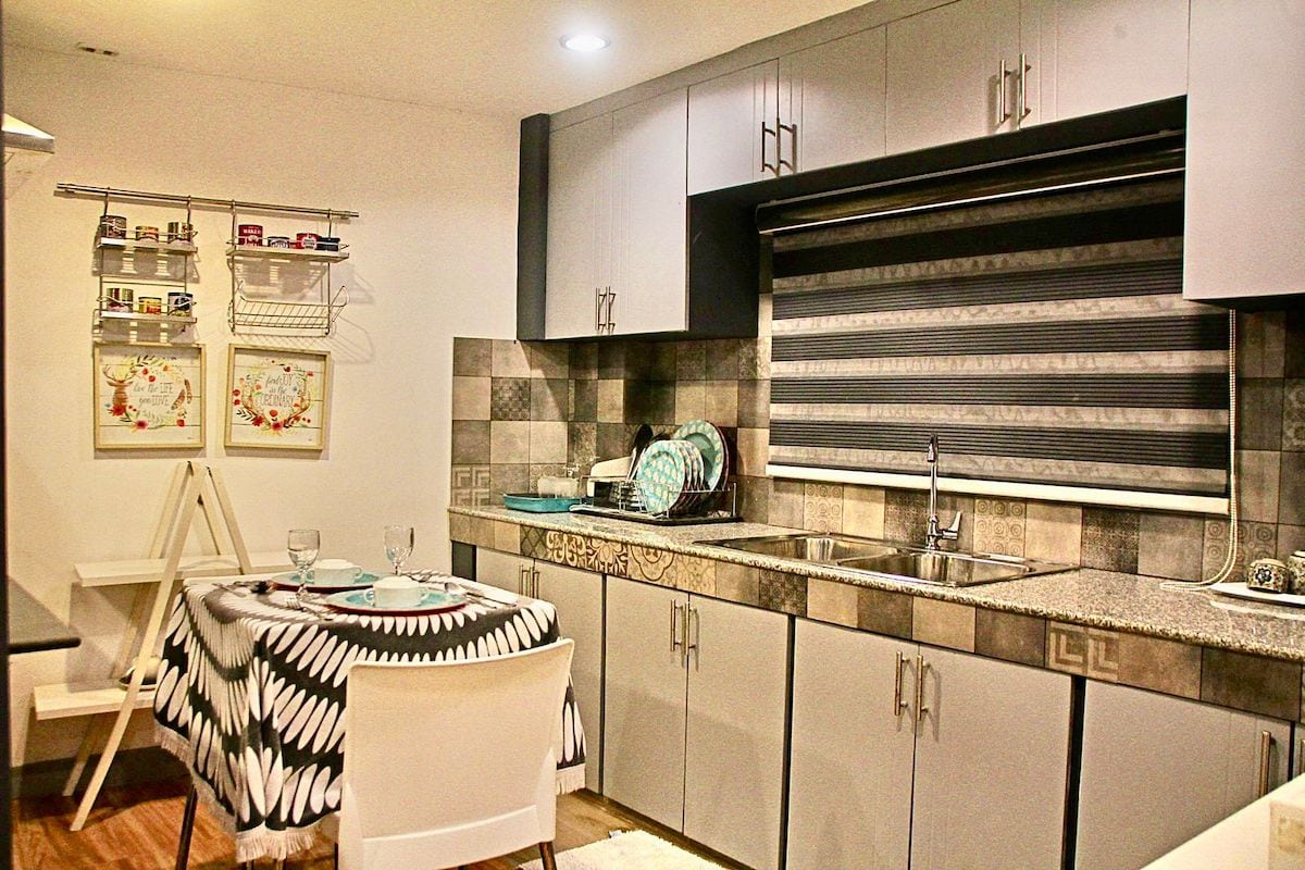 Comoda cucina di un hotel a El Nido, nelle Filippine, dotata di mobili moderni e una piccola zona pranzo.