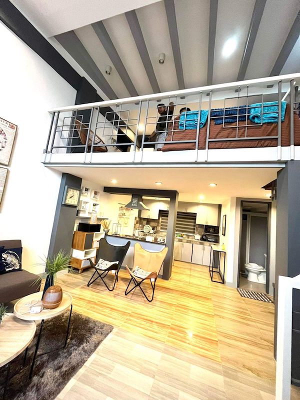 Moderna camera d'albergo loft a El Nido con un'accogliente zona notte al piano superiore e un elegante soggiorno al piano inferiore.