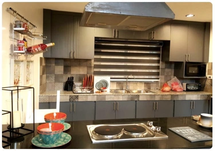 Cucina con elettrodomestici, utensili e piatti colorati.