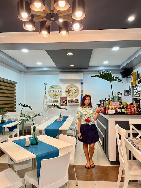 Vista interna di un'accogliente sala da pranzo di un hotel a El Nido, nelle Filippine, con arredamento moderno e un'atmosfera amichevole.