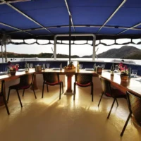 Al fresco dining area on Siren Liveaboard with scenic ocean views.