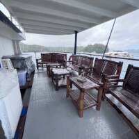 Dolphin Liveaboard deck featuring wooden chairs and tables with ocean views.