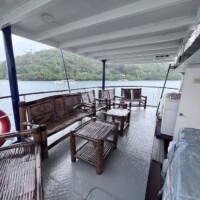 Dolphin Liveaboard deck with seating overlooking the sea and lush islands in the background.