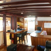 Interior view of Siren Liveaboard in the Philippines, showcasing cozy lounge and dining area.