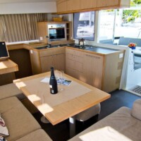 Interior of a luxury yacht with a dining area and kitchen setup.