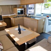 Interior of a luxury yacht with a dining area and kitchen setup.