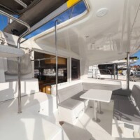 Spacious yacht deck with seating and table, perfect for island hopping in the Philippines.
