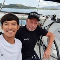 Two men enjoying island hopping tour in the Philippines on a boat.