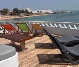 Enjoy seaside relaxation on stylish lounge chairs with stunning ocean views in the Philippines. Al fresco seating with colorful lounge chairs overlooking the sea in the Philippines.