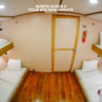 Comfortable four-bed cabin on Manta Queen 2 for island hopping adventures in the Philippines. Cabin interior of Manta Queen 2 with four beds, ideal for island hopping trips in the Philippines.