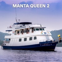 A luxurious yacht named Manta Queen 2 sailing on tranquil waters, ideal for island hopping adventures in the Philippines. Manta Queen 2 luxury yacht cruising in calm waters.