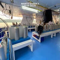 Well-equipped dive deck with tanks and gear on the Manta Queen 3 for Philippine island diving adventures. Diving equipment on the Manta Queen 3 dive deck in the Philippines.