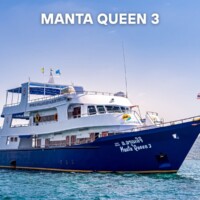 A luxurious yacht used for island hopping in the Philippines, offering scenic views and comfortable amenities. Manta Queen 3 yacht anchored in clear blue waters, ready for island hopping tours in the Philippines.