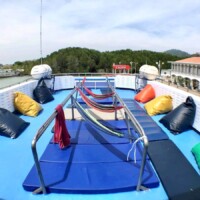 Enjoy a relaxing day on a boat deck with colorful cushions and a beautiful harbor view in the Philippines. Boat deck with vibrant cushions and scenic harbor view in the Philippines.