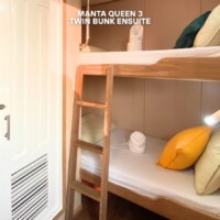 Cozy hotel room featuring a twin bunk bed with an ensuite bathroom, perfect for travelers seeking comfort and convenience. Bunk bed with ensuite bathroom in a compact hotel room.