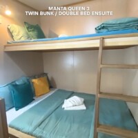 Cozy bunk bed setup with a double bed on the bottom and twin bed on top, ideal for travelers seeking comfort in the Philippines. Bunk bed with double bed below and twin bed above, perfect for family or group stays.